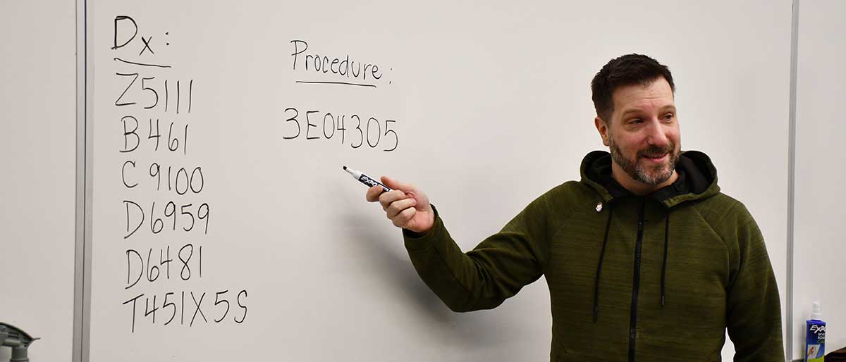 Health Information Management instructor writing on a white board