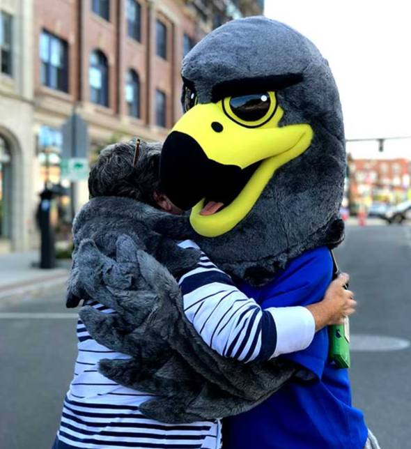 BCC's Falcon Mascot hugging an employee